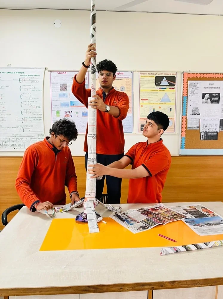 Senior students building a newspaper tower during a creative learning activity at Manaskriti School Faridabad