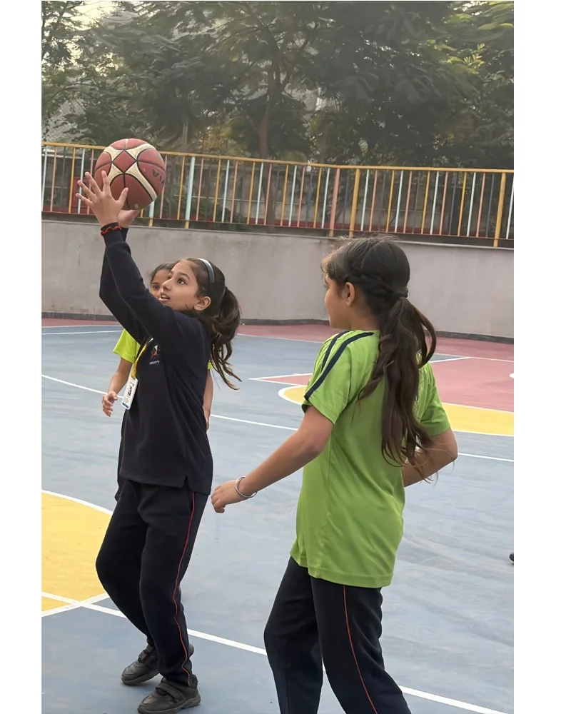Students playing basketball during the school day at Manaskriti School Faridabad