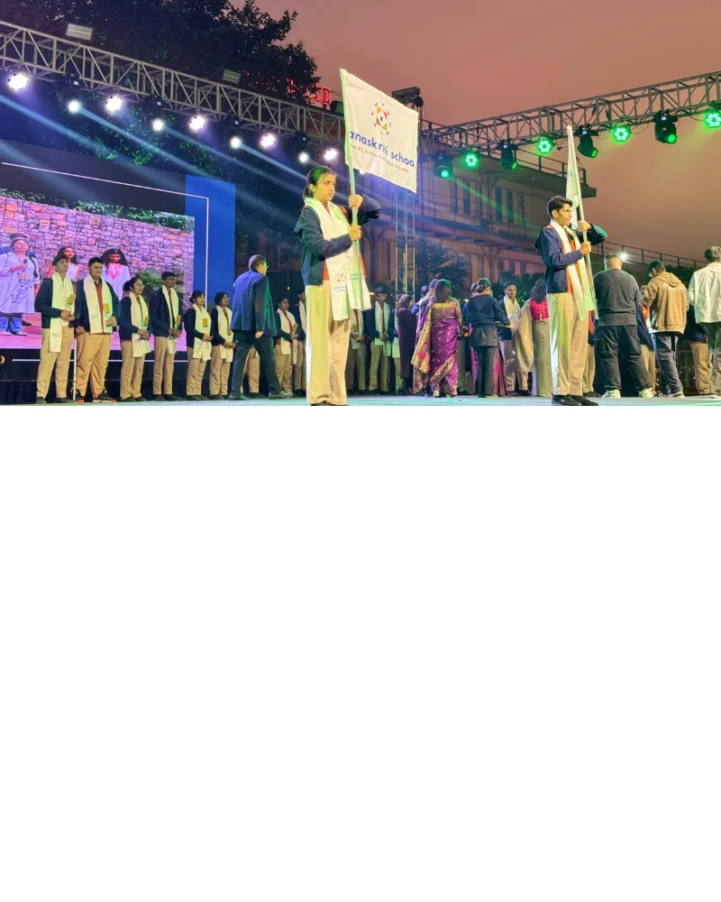 Manaskriti School students holding flags during a school event in Faridabad