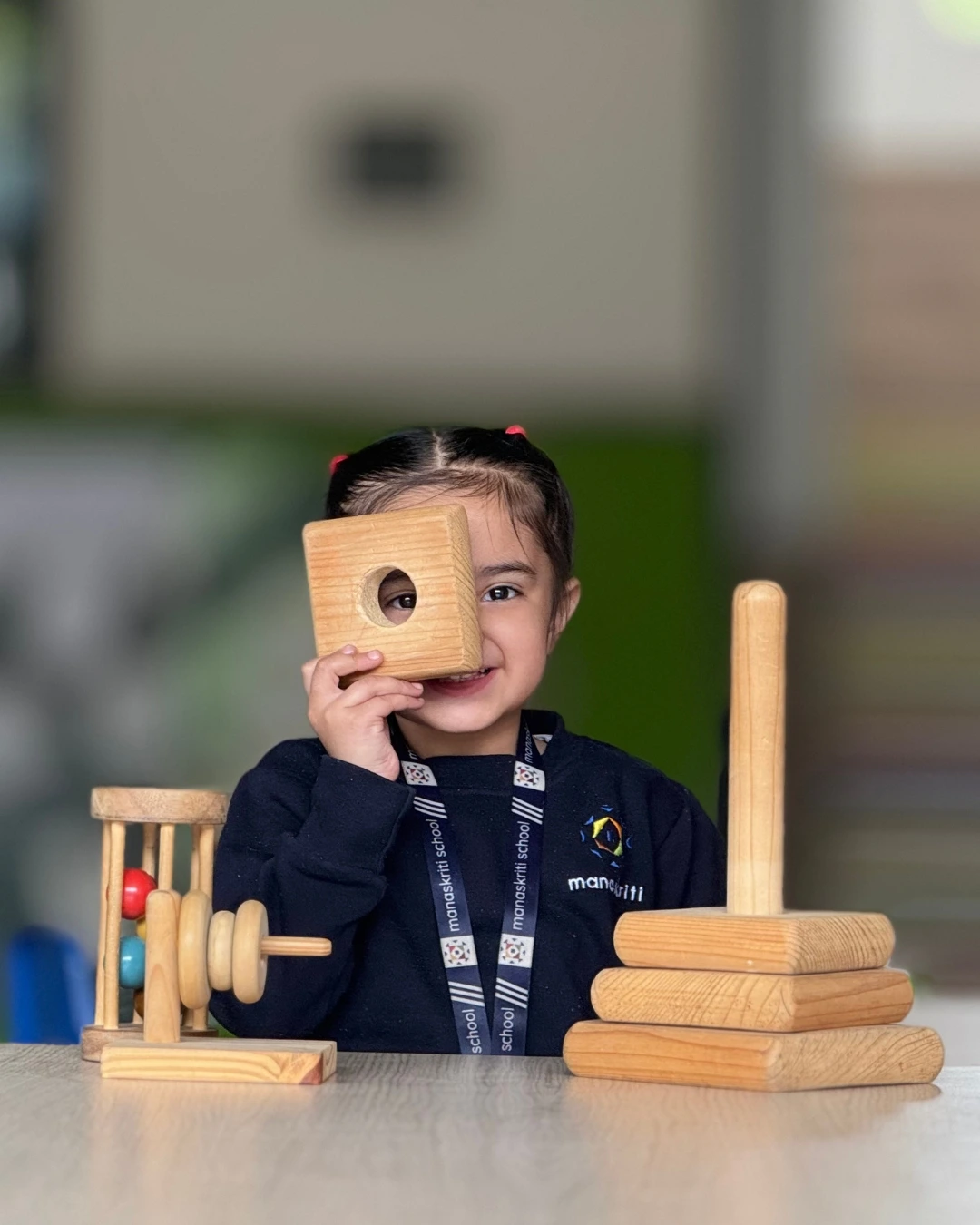 Students exploring wooden learning toys at Manaskriti School Faridabad