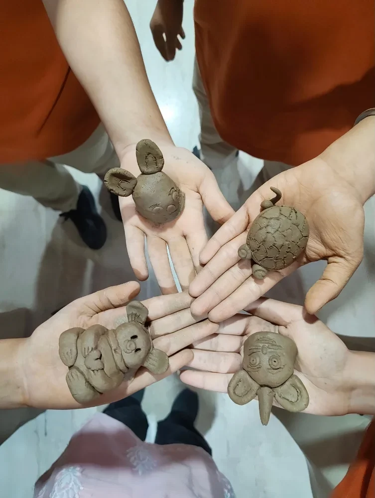 Students collaborating while creating clay sculptures at Manaskriti School Faridabad