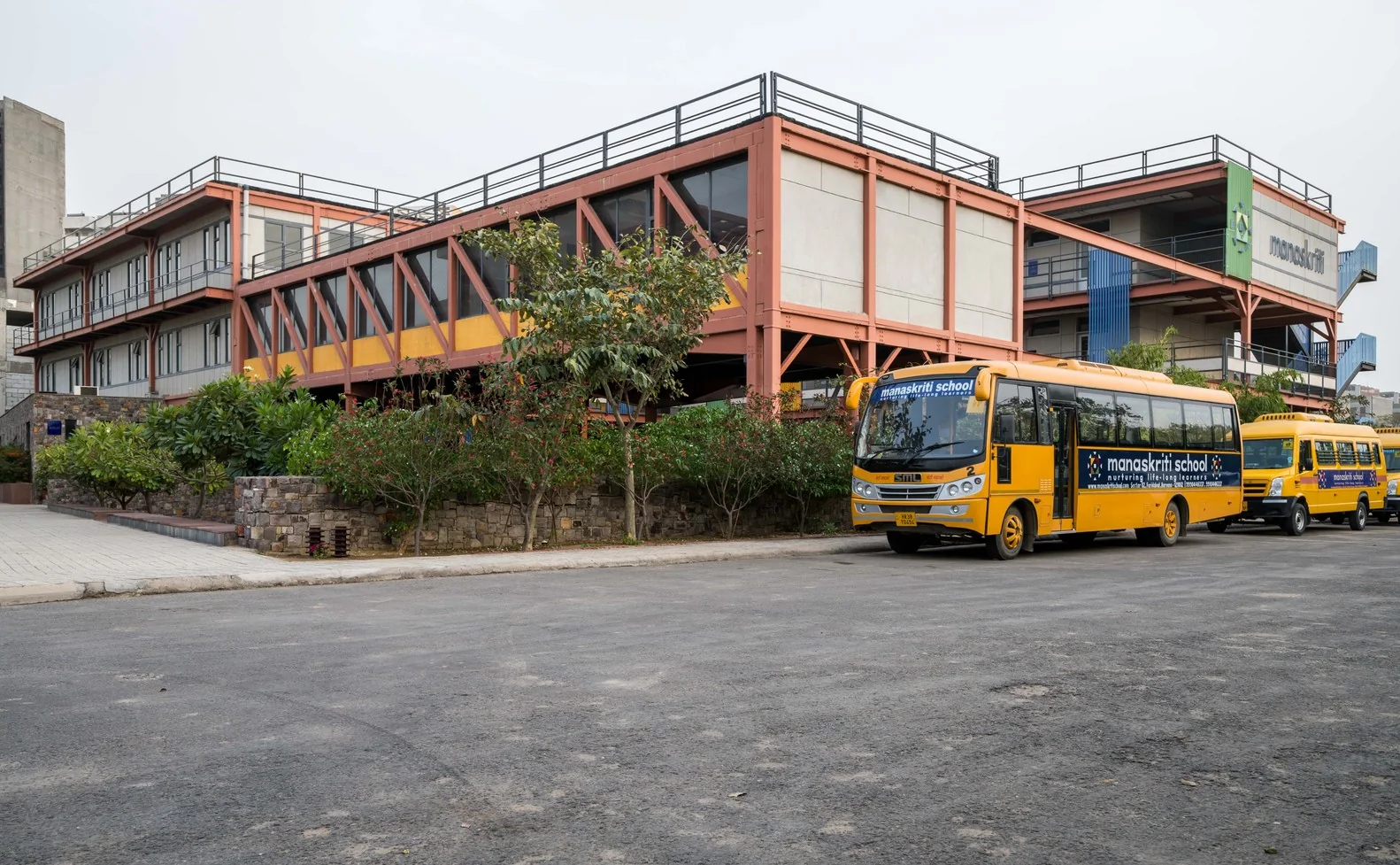 Yellow school buses parked at Manaskriti School in Sector 82 Greater Faridabad